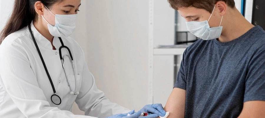 Médica com uma agulha retirando sangue do paciente